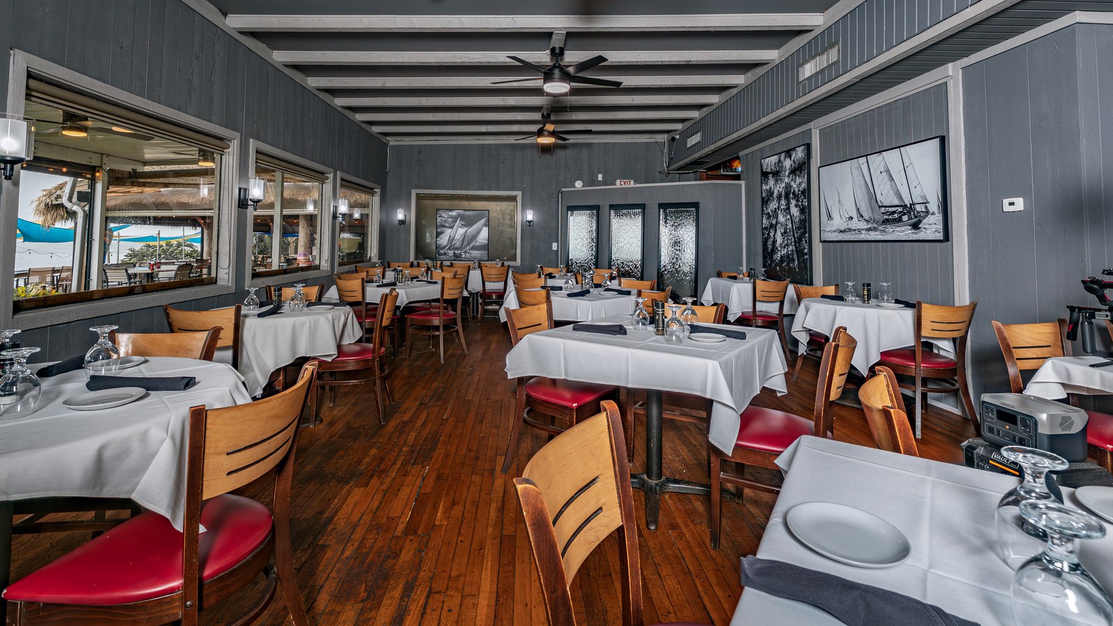 White-tablecloth dining room with river-view windows at The Shack in Palm Bay