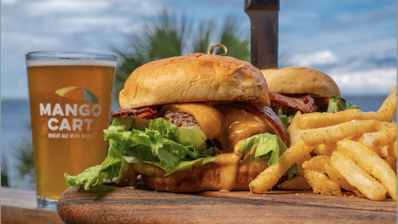 Cheeseburger, fries, and a pint served by the water at The Shack in Palm Bay