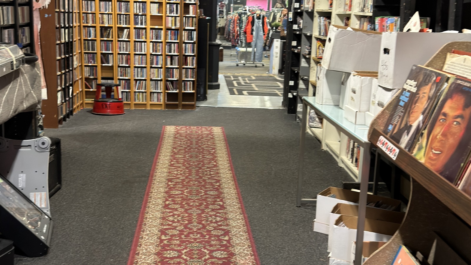 Carpeted passage with tall bookcases and more rooms beyond at Philly AIDS Thrift