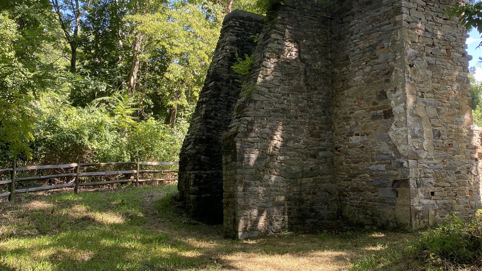 Stone furnace ruins standing in the wooded Manor Area of the park.