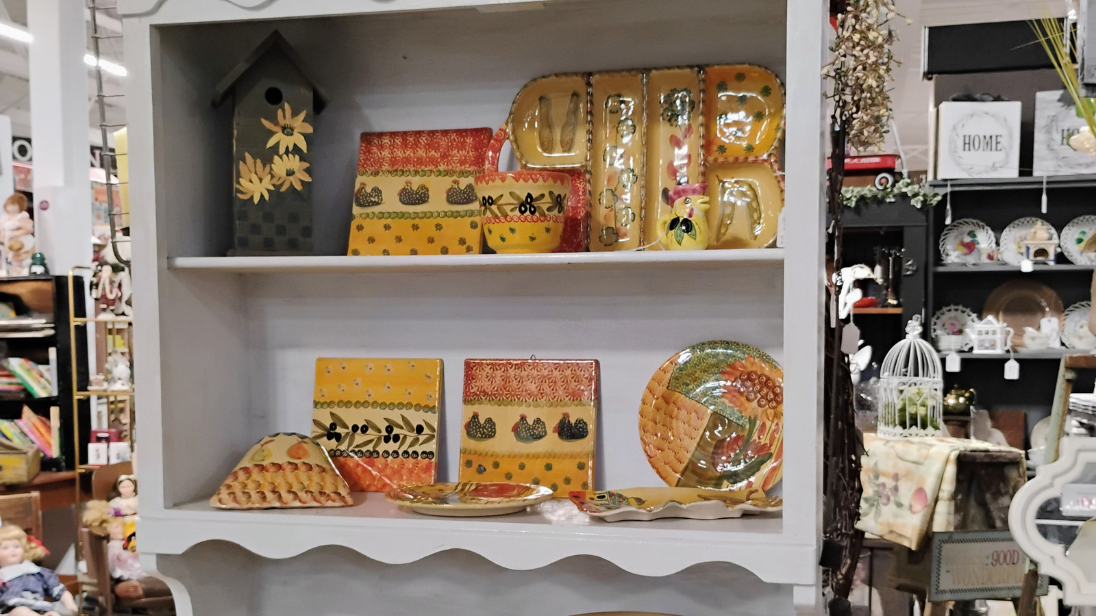 White country hutch filled with colorful pottery and tabletop pieces at America's Antique Mall in Highland
