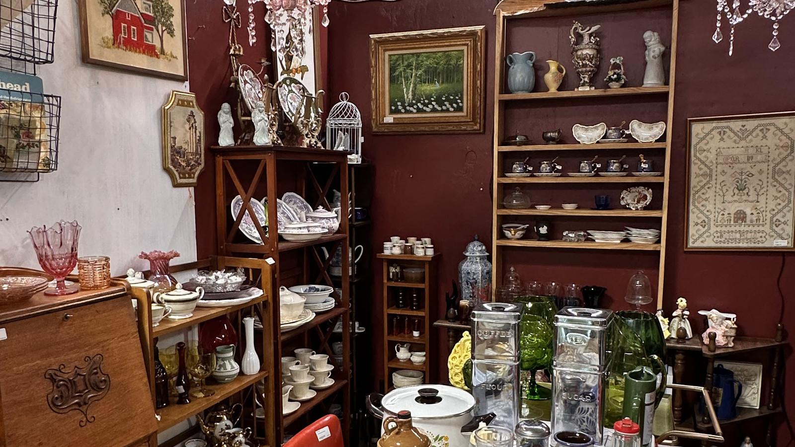 Vintage dining vignette with chandeliers, red chairs, and layered housewares at America's Antique Mall in Highland