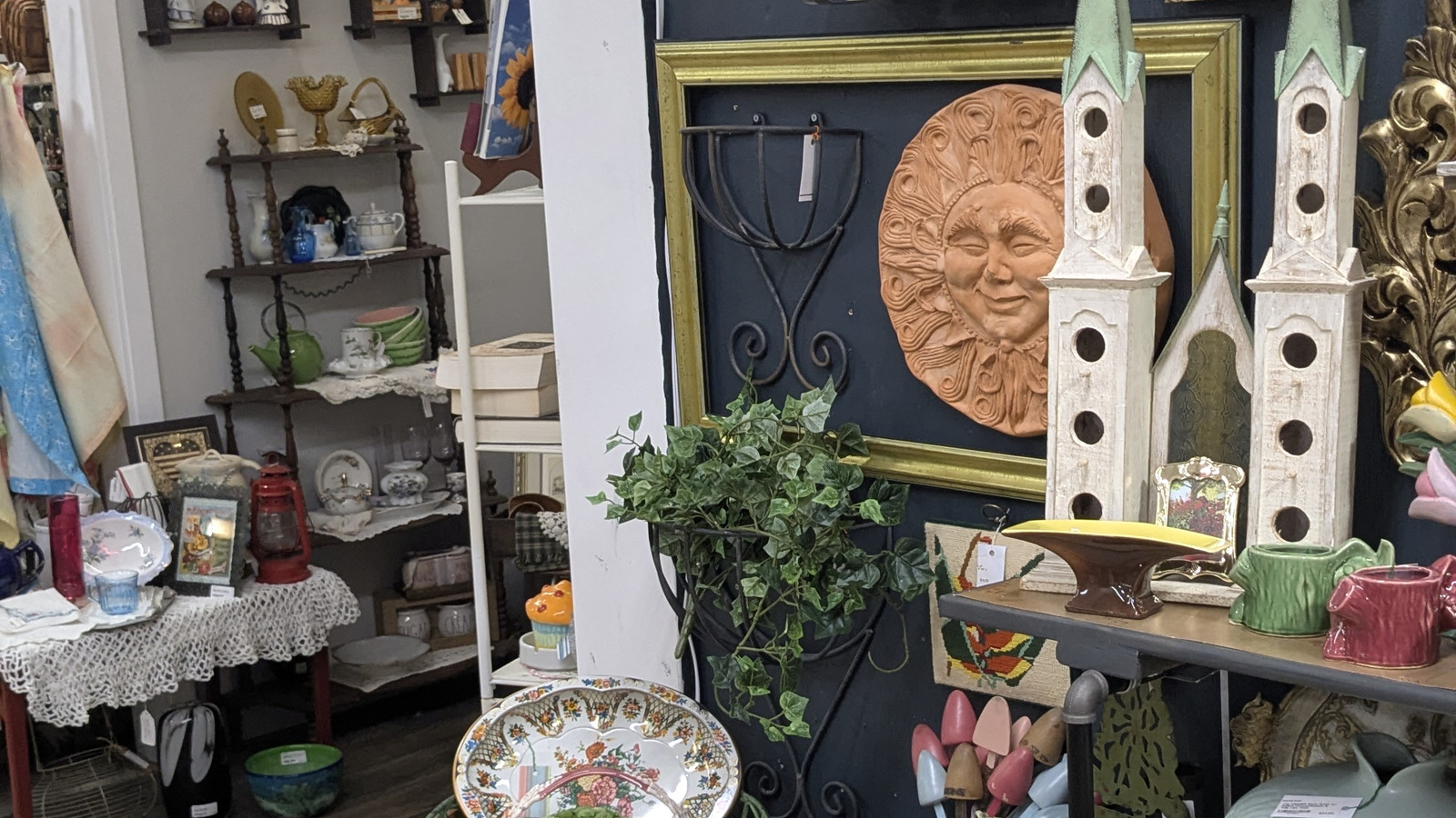Layered wall decor, shelves, and garden-style pieces inside America's Antique Mall in Highland