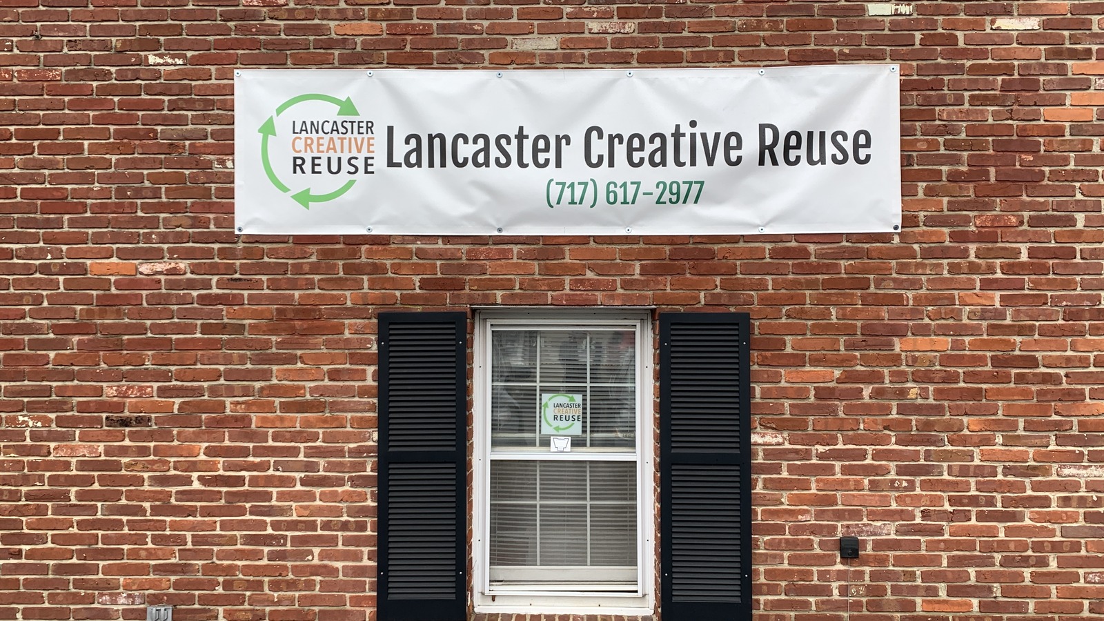 Brick exterior sign for Lancaster Creative Reuse along Oregon Pike in Lancaster.