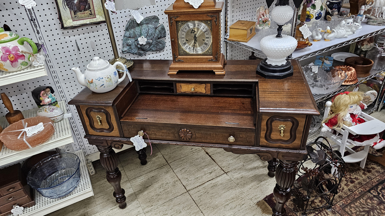 Antique writing desk, mantel clock, and milk-glass lamps inside Markle Exit 286 Antique Mall