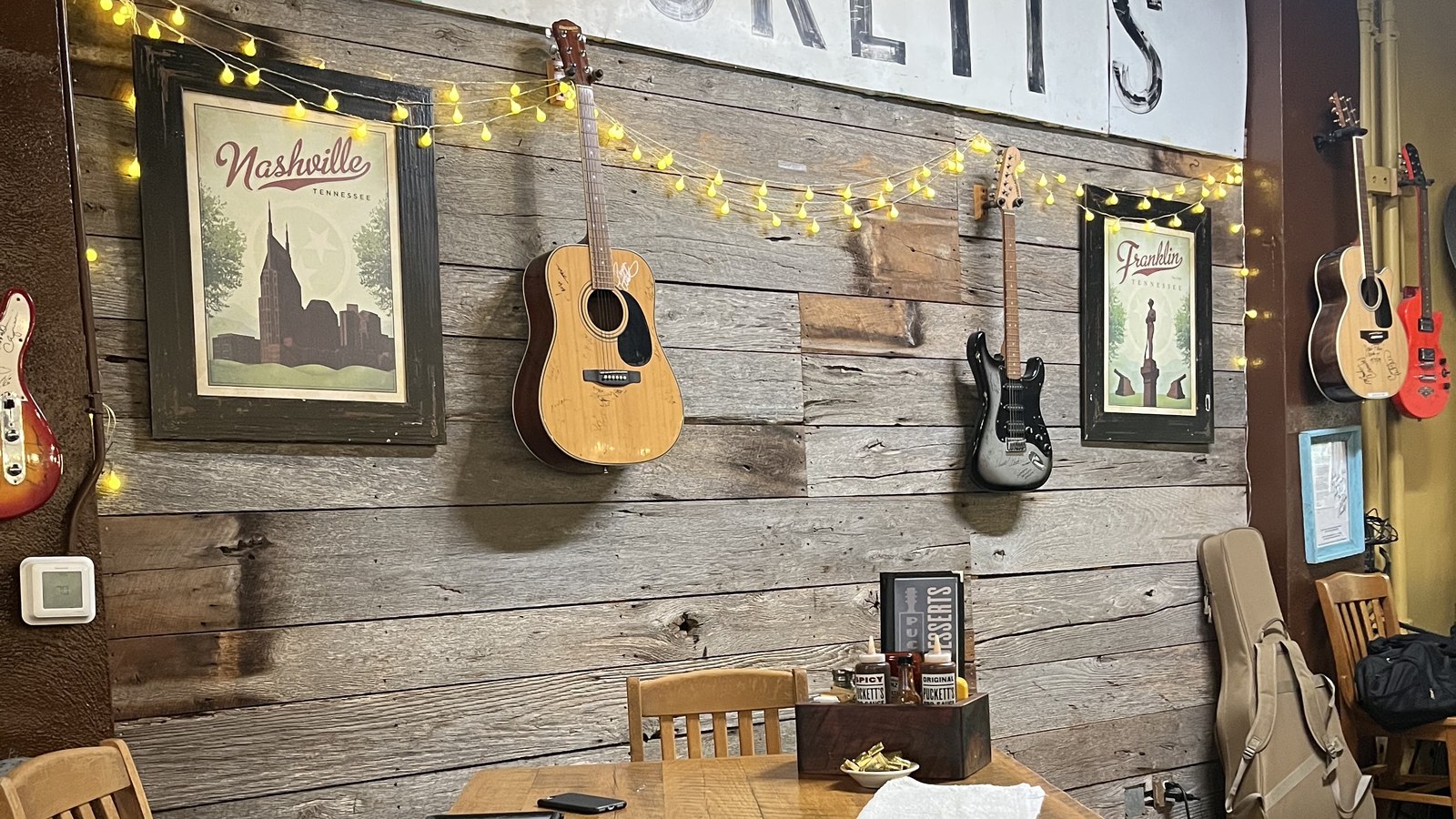 Large Puckett's wall sign with hanging guitars and Tennessee prints inside the restaurant