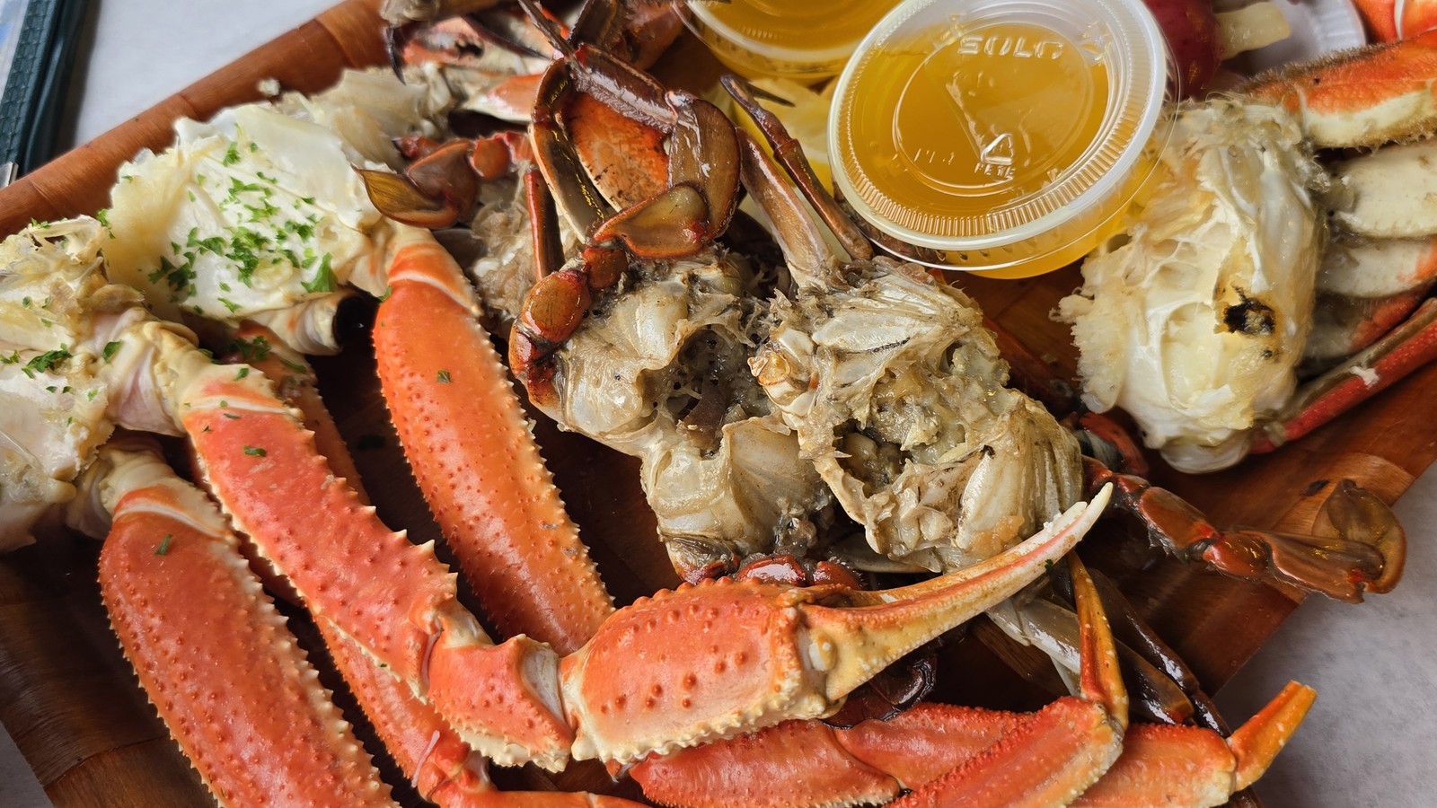 Crab sampler board with butter cups and shellfish at Rustic Inn Crabhouse