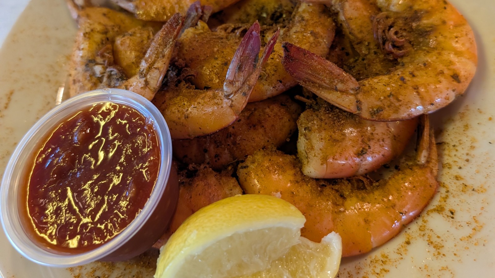 Seasoned shrimp plate with lemons and cocktail sauce at Rustic Inn Crabhouse