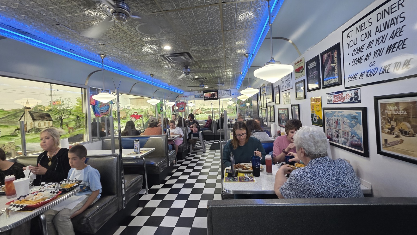 Checkerboard floor and blue-lit dining room inside Mel's Classic Diner