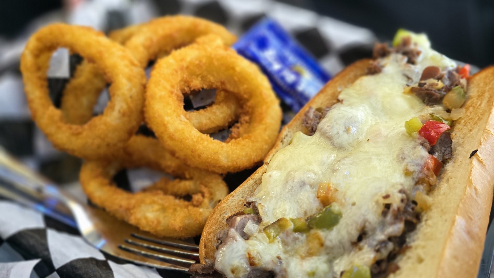 Cheesesteak sandwich with onion rings at Mel's Classic Diner