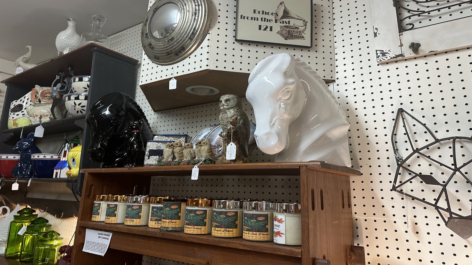 Eclectic shelf with owl figurines, a glossy horse head, mirrors, and vintage decor at Brown County Antique Mall
