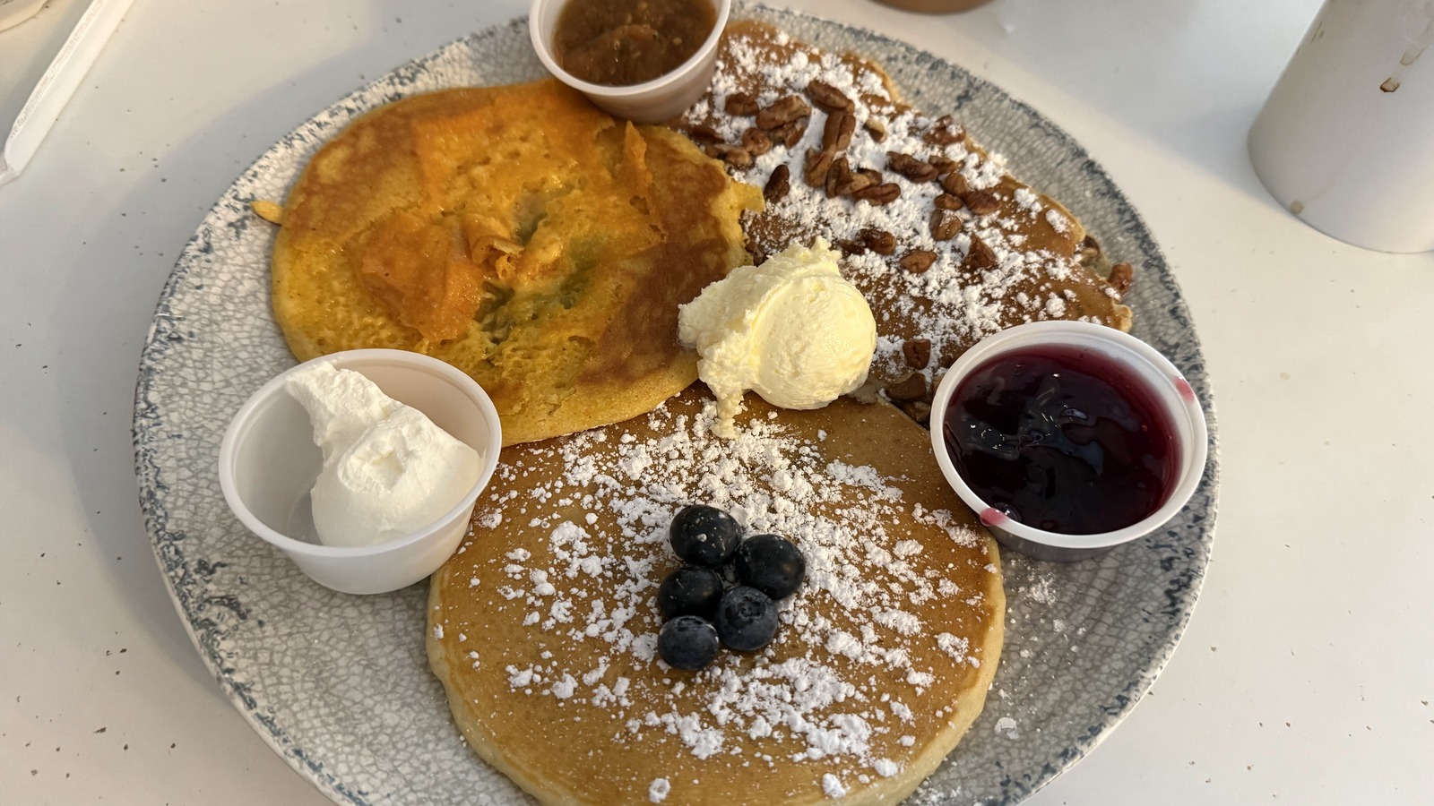 Sweet potato and blueberry pancakes with butter, syrup, and powdered sugar at The Pancake Pantry