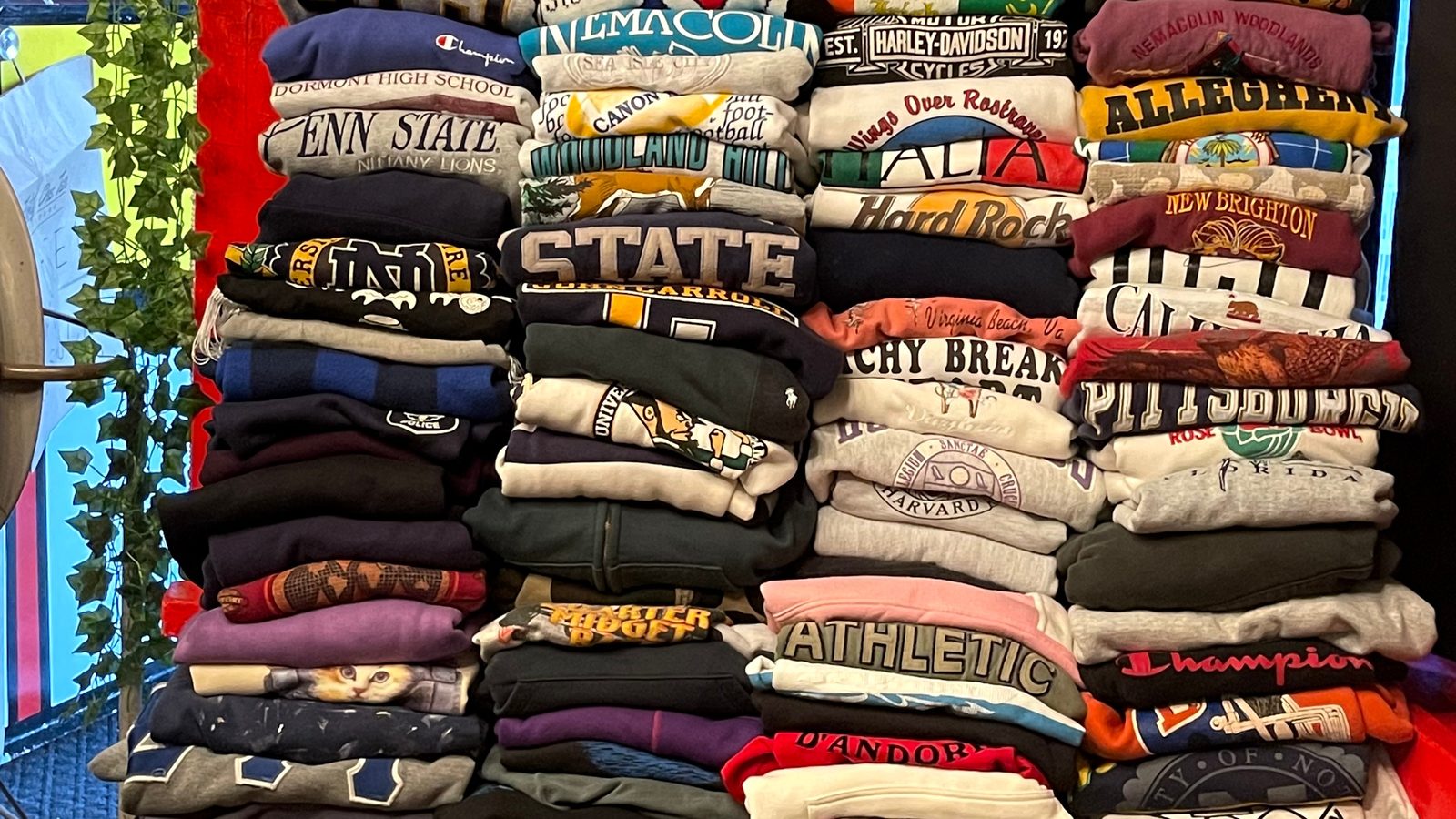Towering folded stacks of vintage sweatshirts at Fifty One Ten Vintage in Pittsburgh.