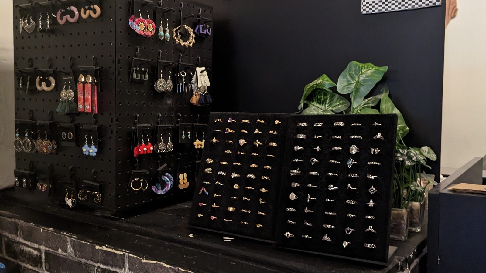 Earrings and rings arranged on a dark display counter at Fifty One Ten Vintage in Pittsburgh.