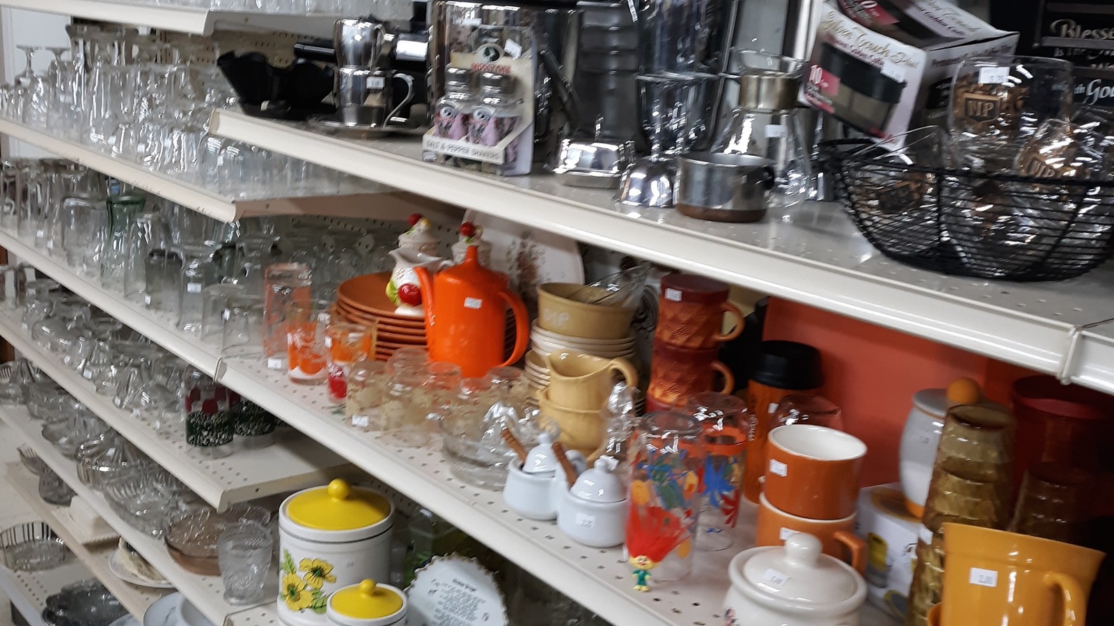 Glassware and kitchen shelves inside Green Scene Thrift Store in Erie