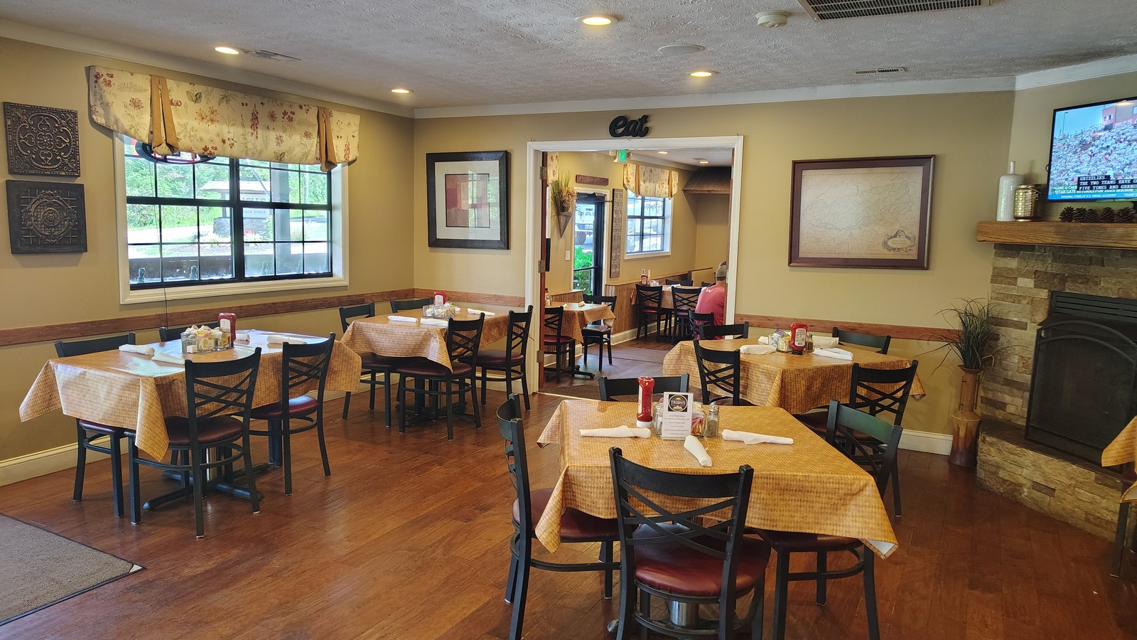 Warm dining room with wood floors and fireplace inside Trish's Mountain Diner