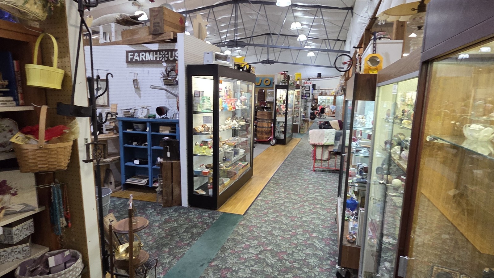 Carpeted corridor lined with booths at Treasure Mart Antique Mall