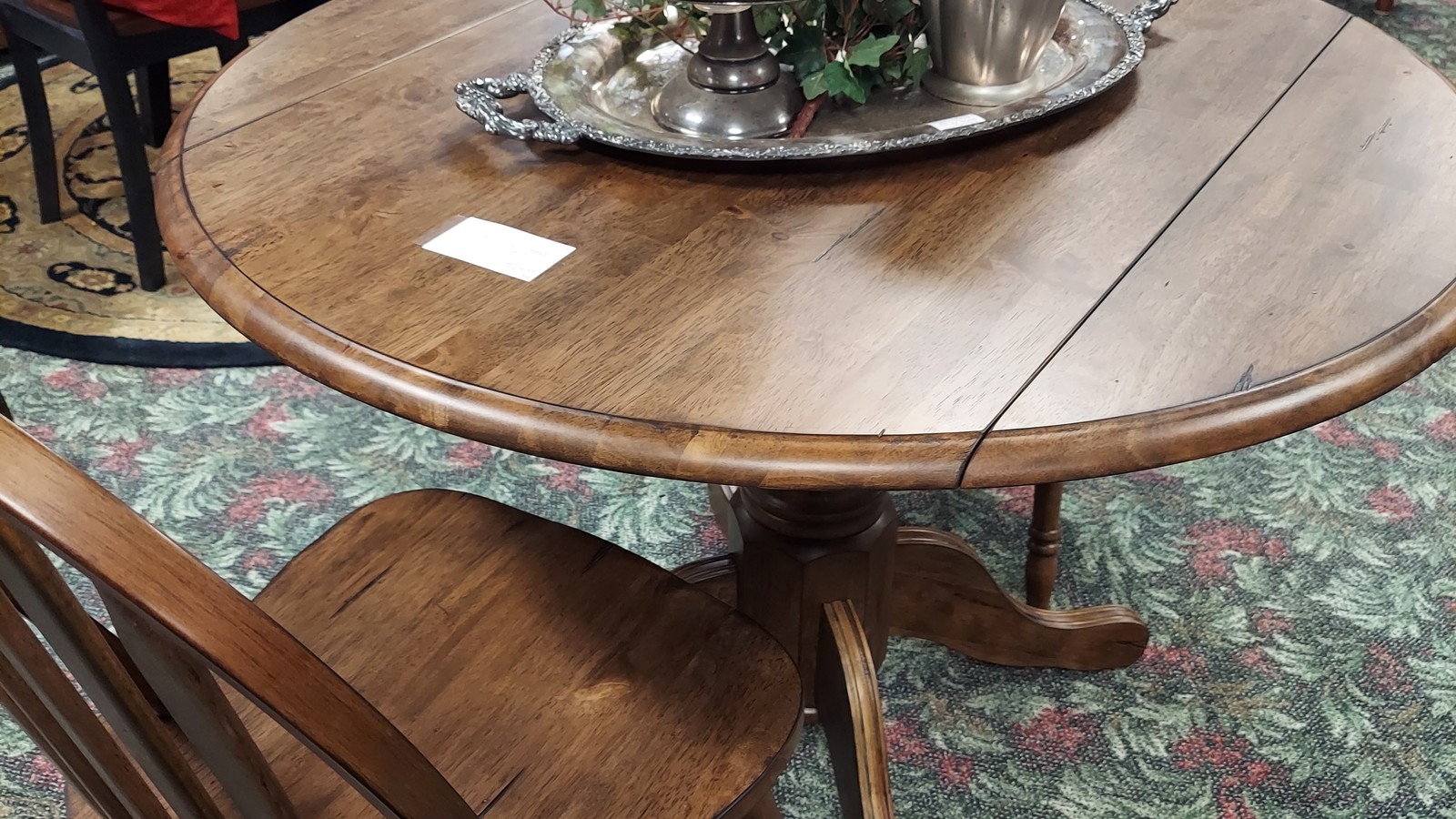 Round wooden table and chairs displayed at Treasure Mart Antique Mall