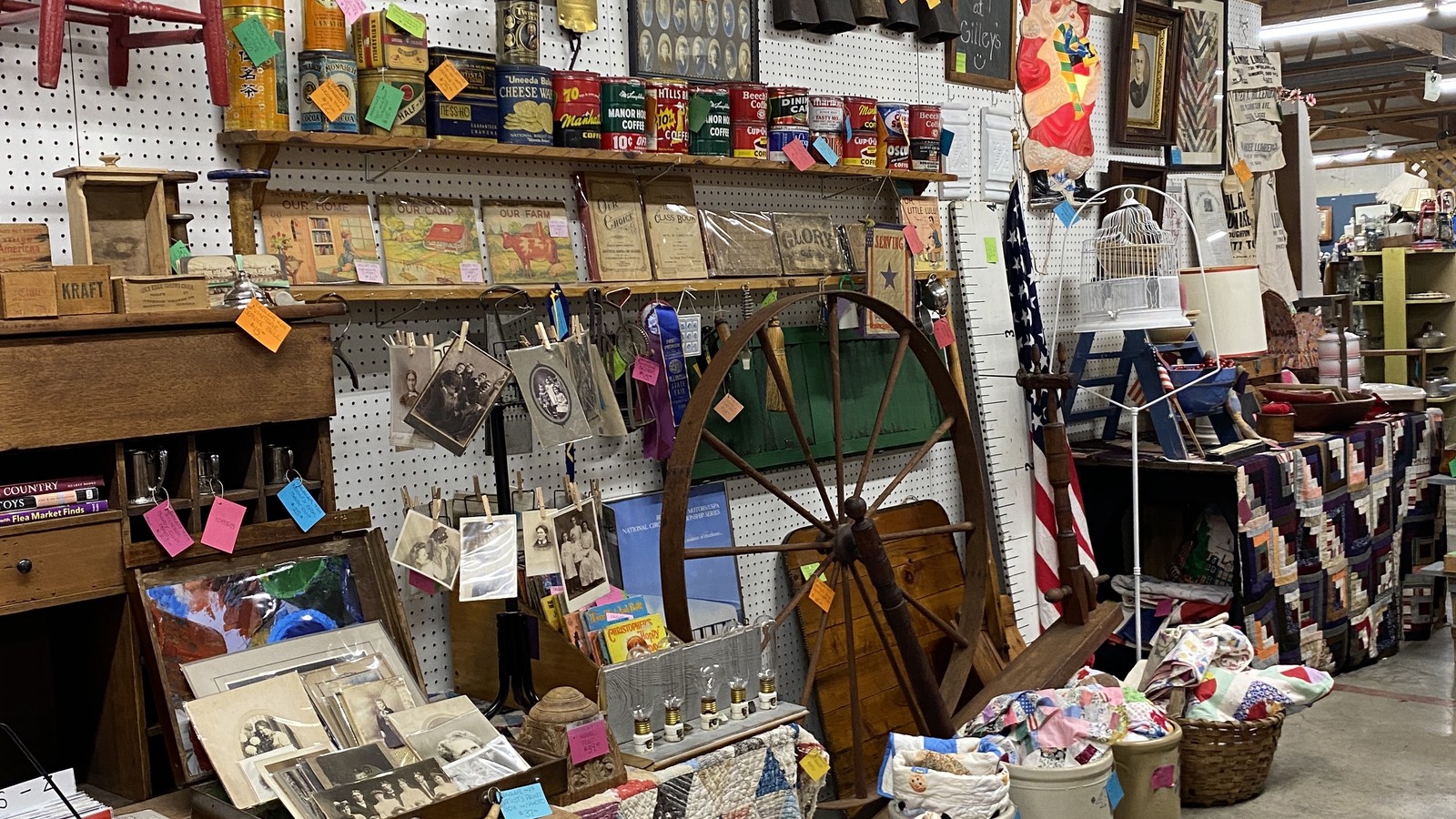 Country booth packed with decor beside a wide aisle at Gilley's Antique & Decorator Mall