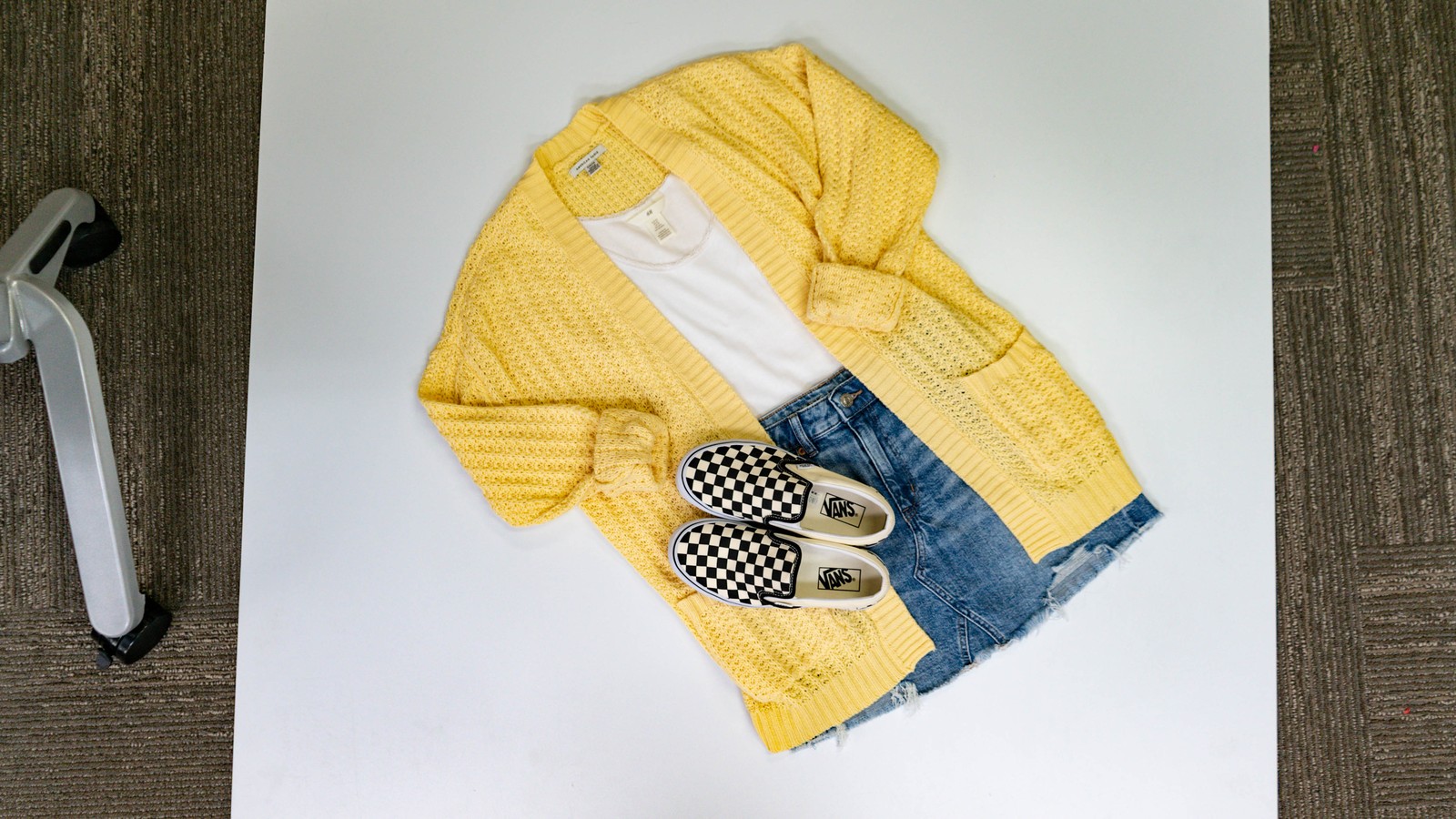 Yellow cardigan, denim shorts, and checkerboard shoes styled together at Uptown Cheapskate West York.