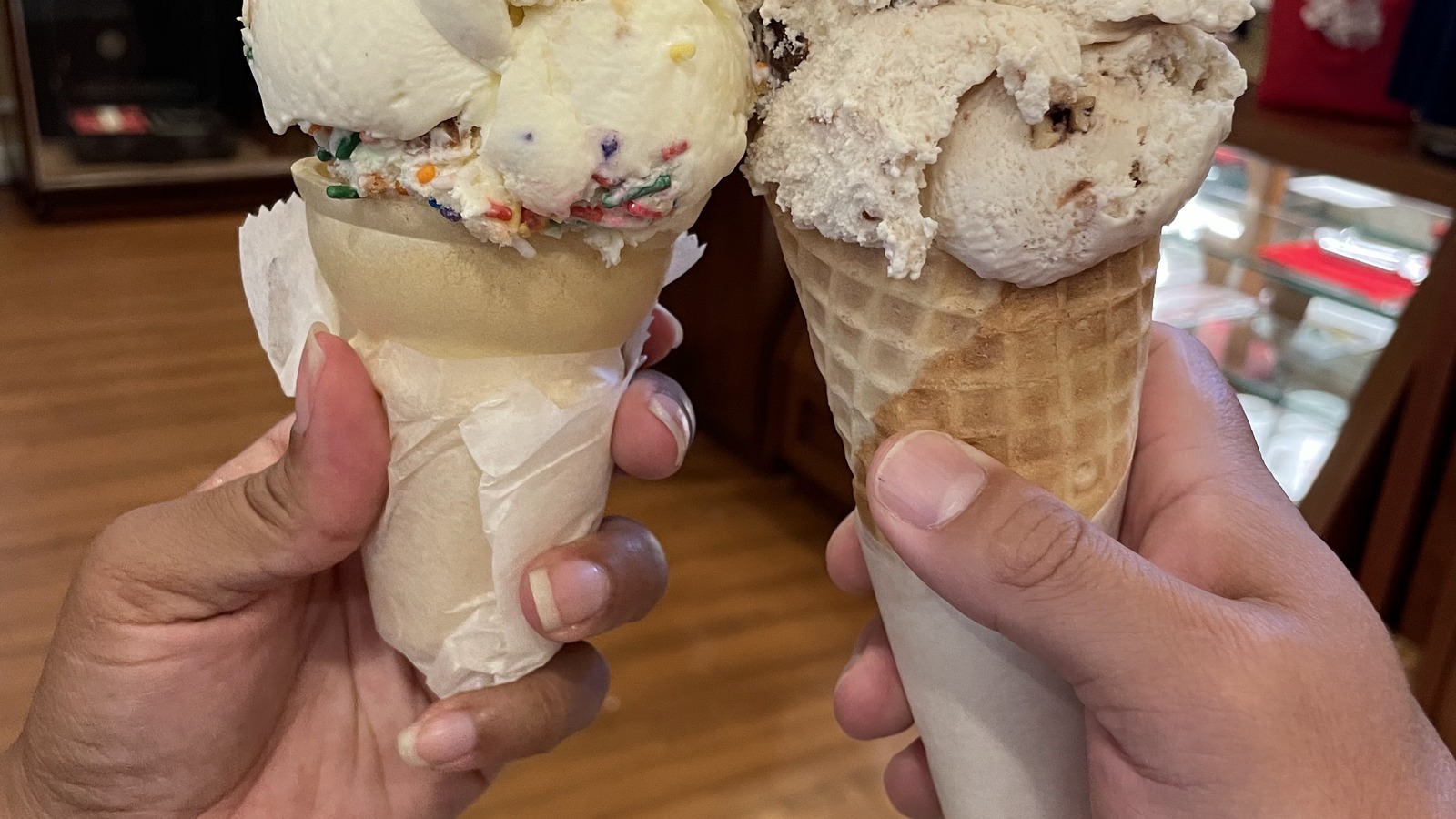 Two generously scooped waffle cones inside Leopold's Ice Cream