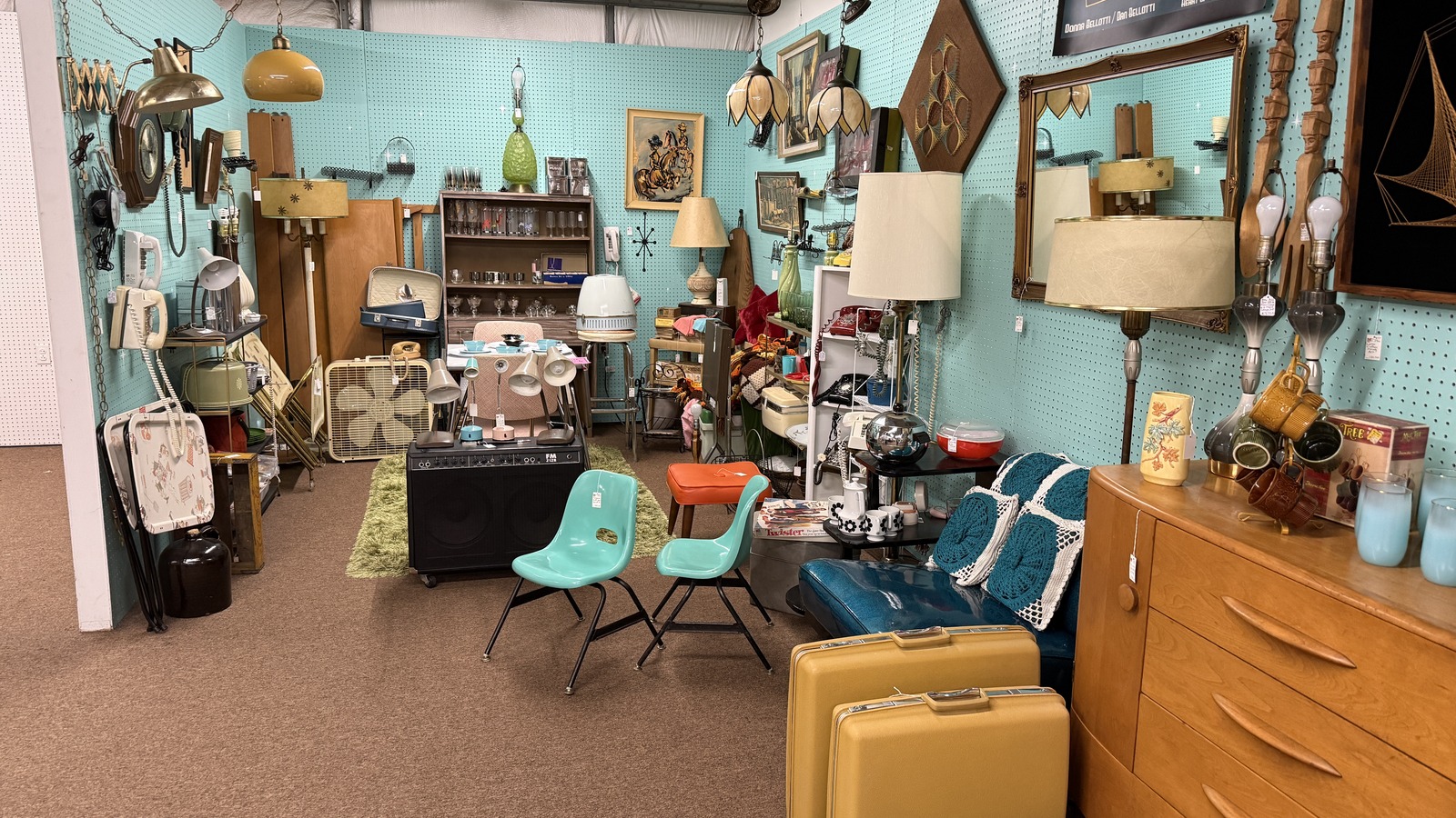 Mid-century booth with turquoise walls, vintage lamps, phones, and low seating