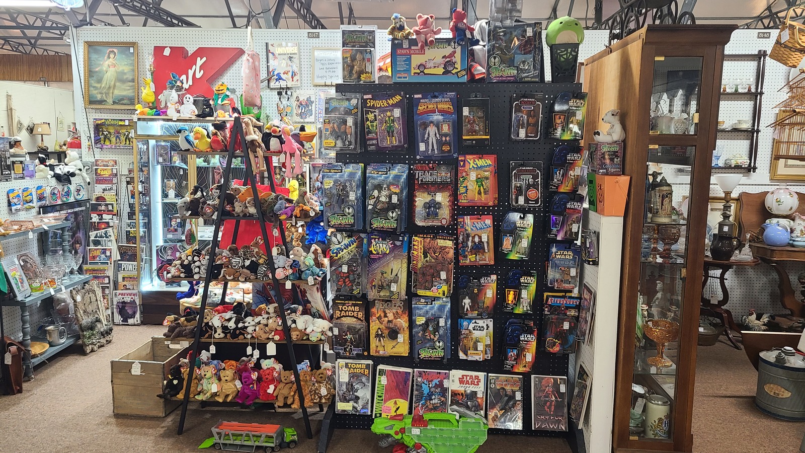 Pop-culture booth filled with comics, action figures, plush toys, and colorful collectibles