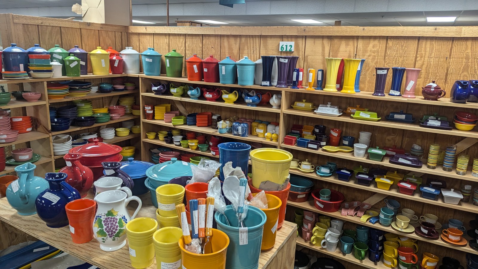 Shelves packed with colorful glassware and collectible tumblers inside I-76 Antique Mall
