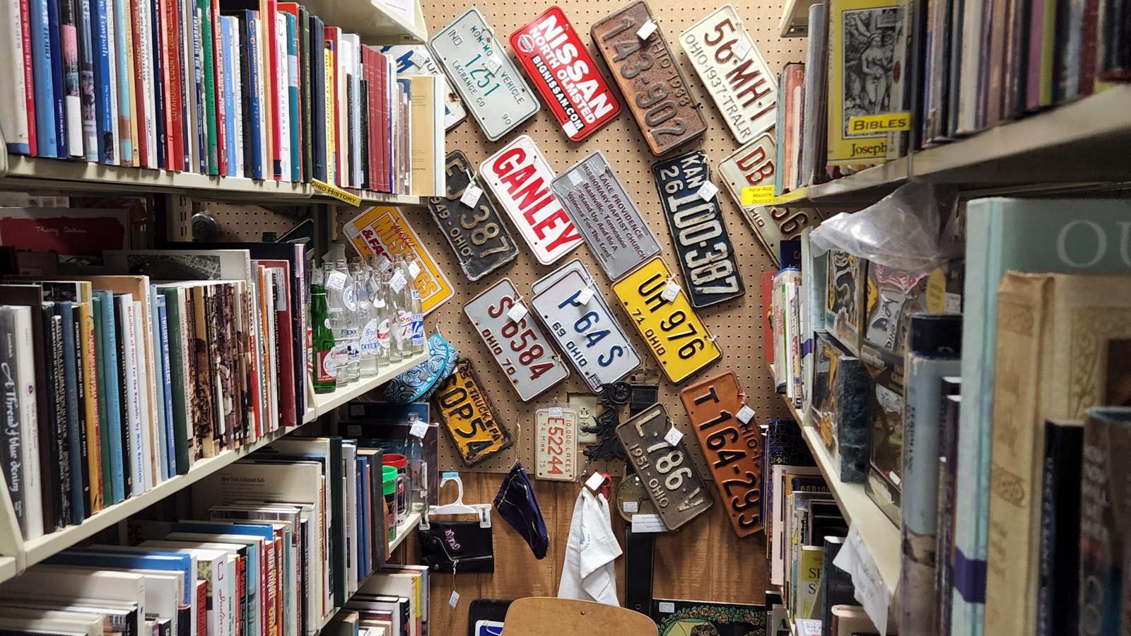 Narrow aisle lined with bookcases, vintage books, and media shelves inside I-76 Antique Mall