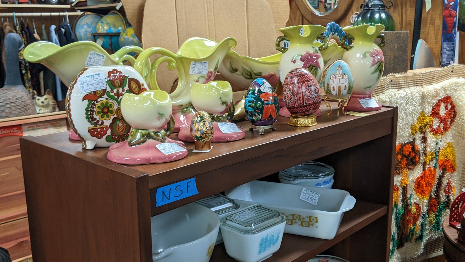 Pottery, pitchers, bowls, and kitchenware displayed on a shelf inside I-76 Antique Mall