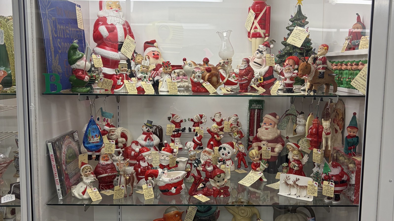 Figurines and small collectibles arranged inside a glass display case at I-76 Antique Mall