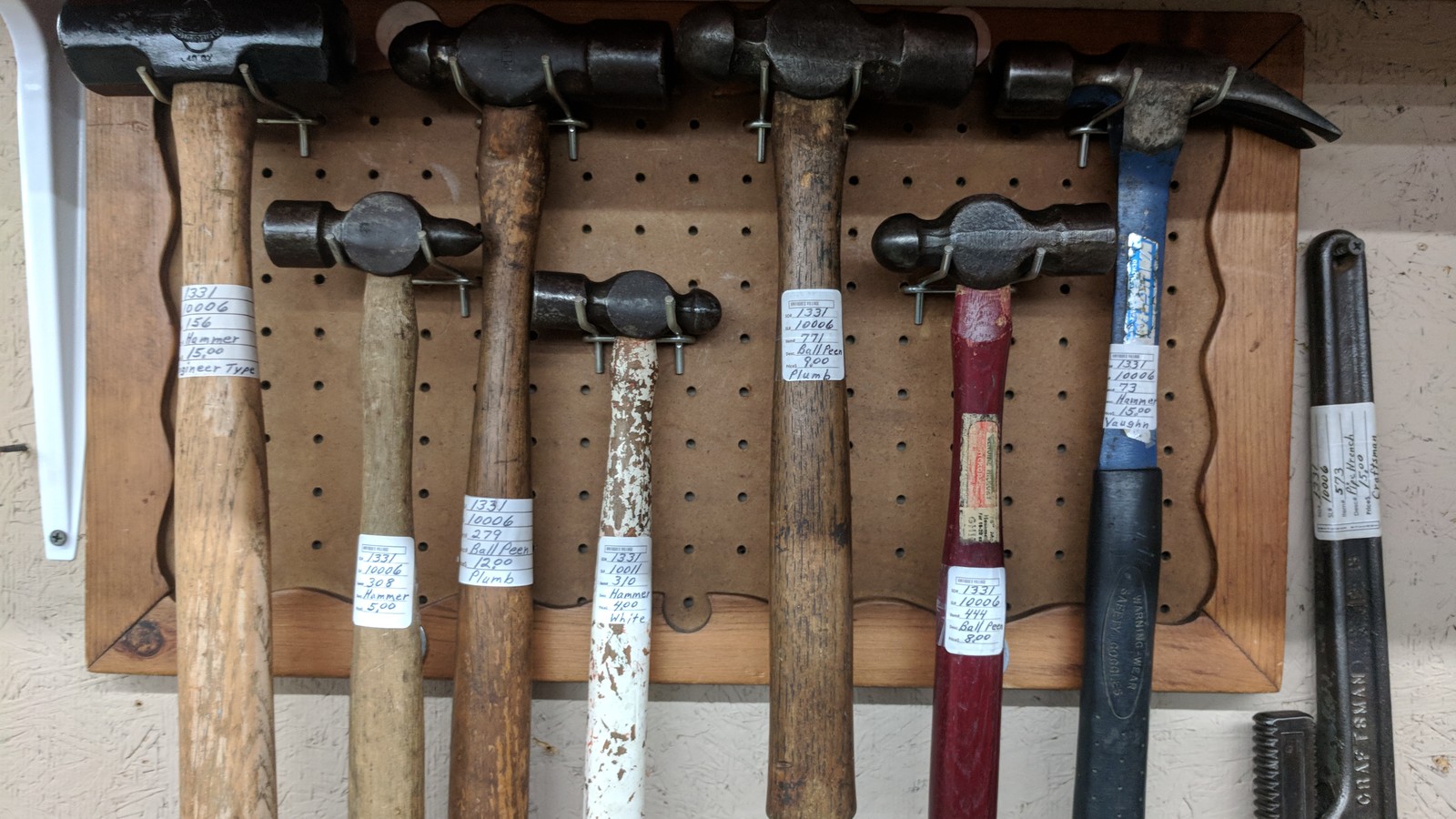Vintage hammers and old tools arranged on a pegboard display inside Antiques Village