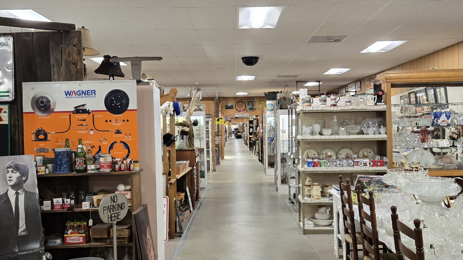 Long central aisle lined with antiques, glassware, and booth displays inside Jeffrey's Antique Gallery