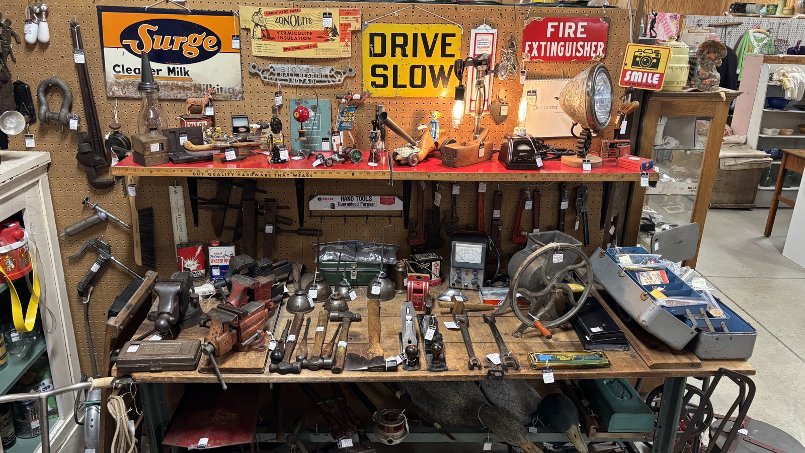 Vintage tools, signs, and industrial antiques arranged on a display wall at Jeffrey's Antique Gallery