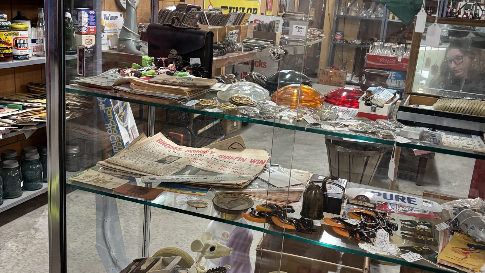 Glass case filled with paper ephemera, colored lenses, and small collectibles at Jeffrey's Antique Gallery