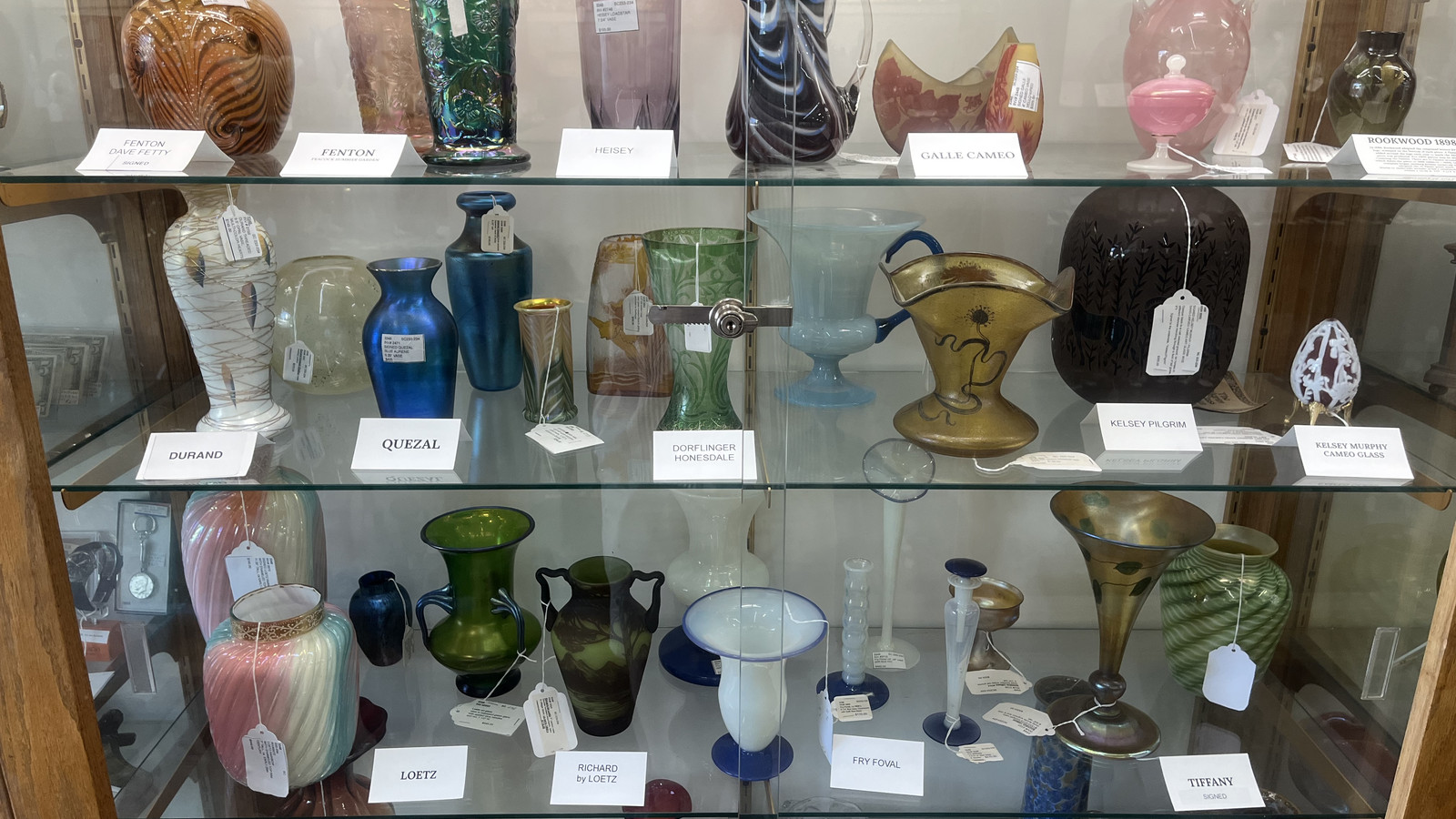 Shelves of colorful vintage glassware arranged inside a display case at Medina Antique Mall