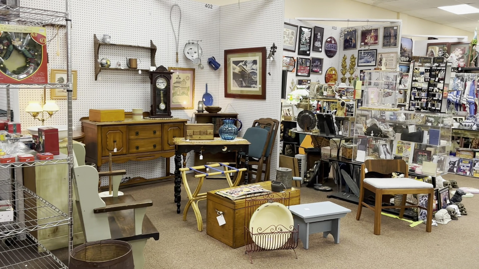 Open room of framed art, small furniture, and mixed vintage decor at Medina Antique Mall
