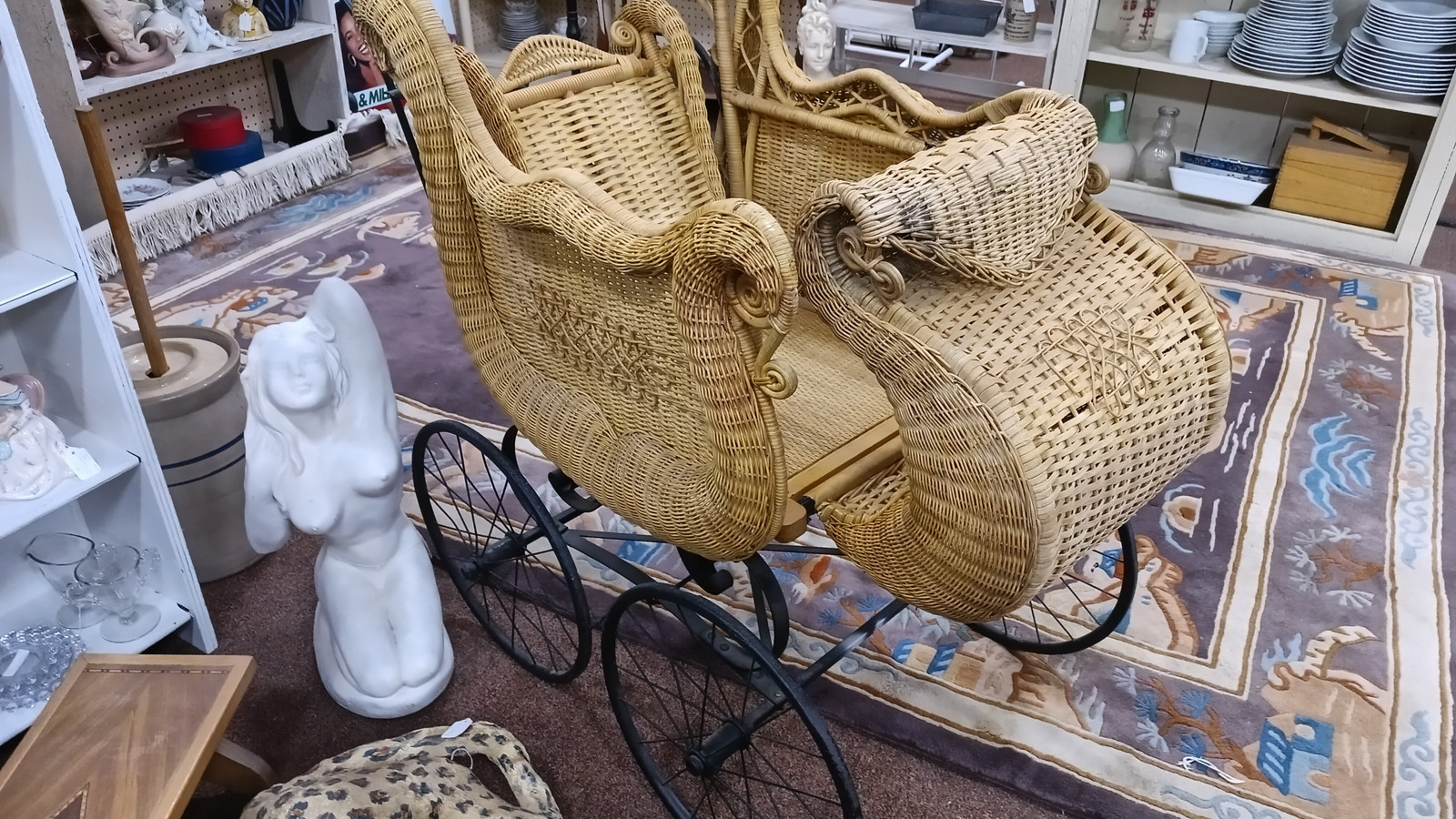 Wicker peacock chair and woven furniture arranged over patterned rugs at Medina Antique Mall