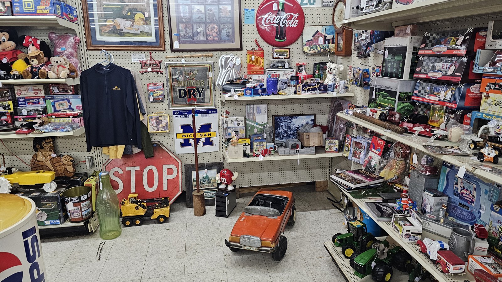 Pop-culture signs, toy vehicles, and shelves of collectibles inside Maumee Antique Mall