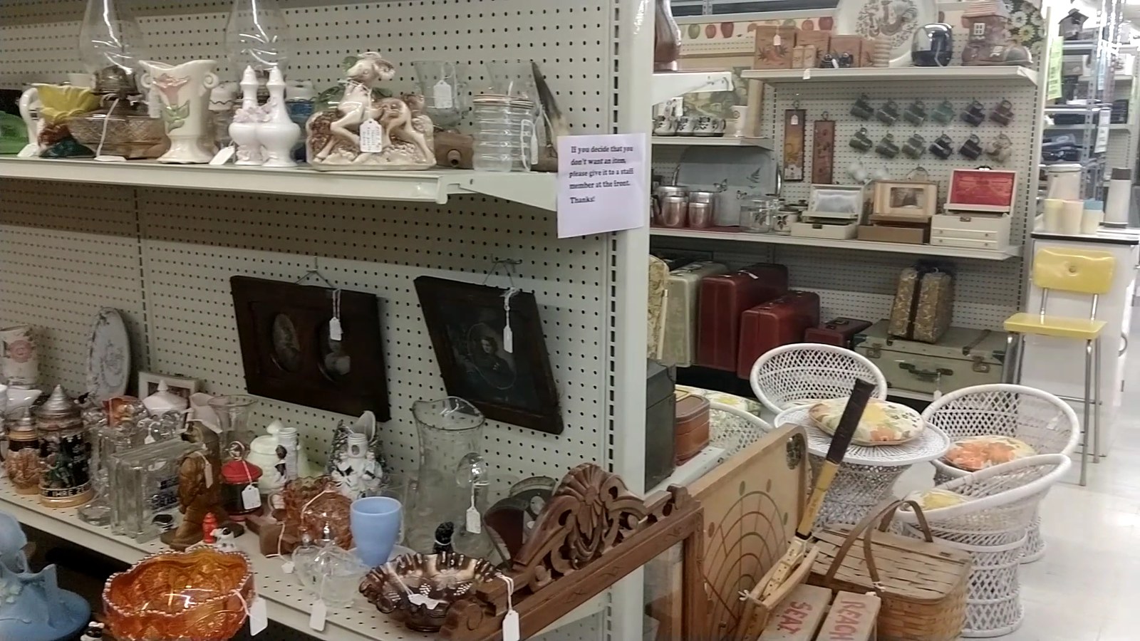 Wicker seating, glassware, and cottage-style shelves inside Maumee Antique Mall