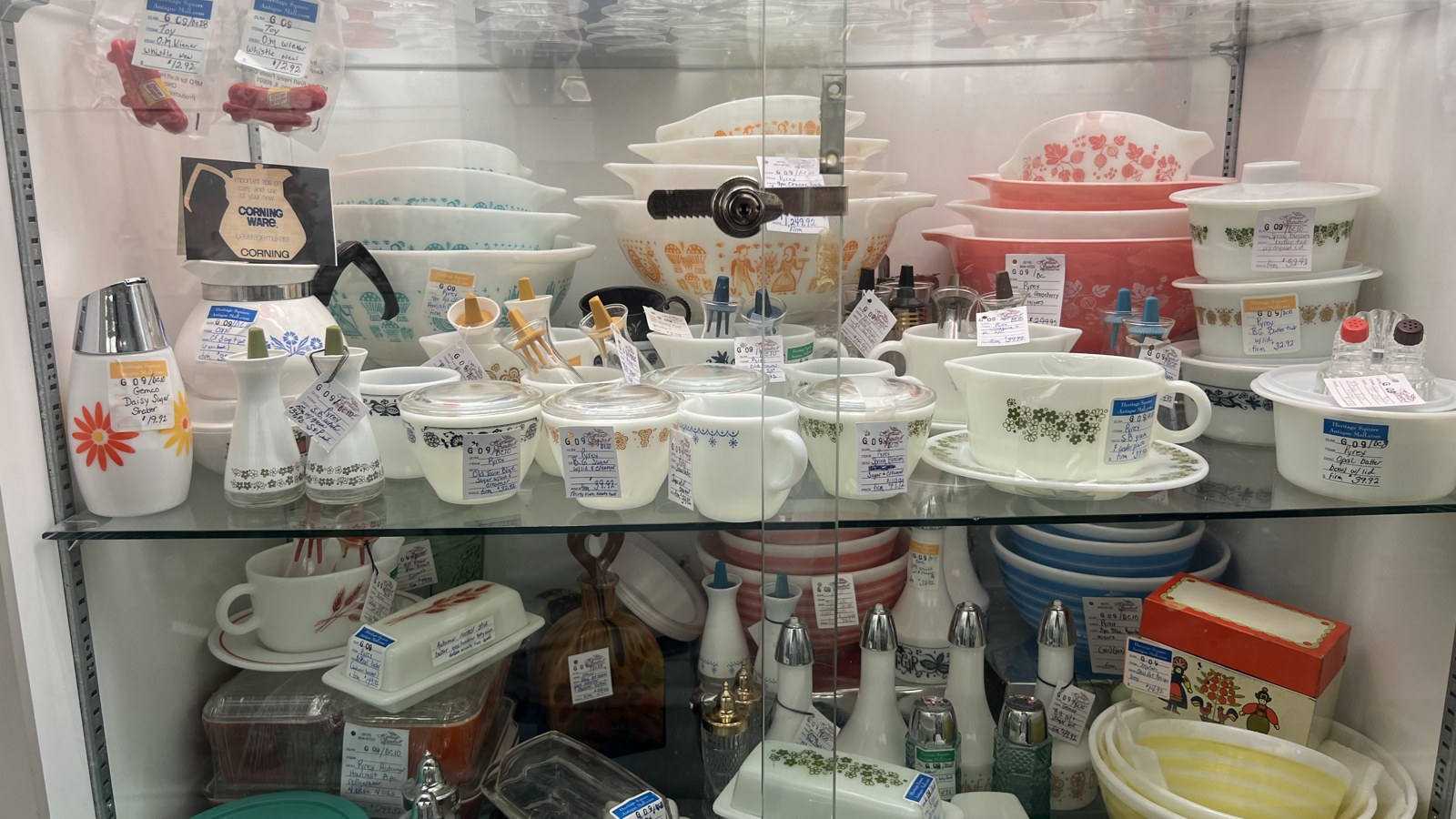 Locked display case filled with vintage Pyrex, CorningWare, and retro kitchen pieces at Heritage Square Antique Mall