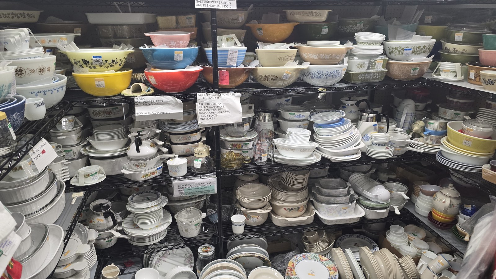 Shelves packed with vintage mixing bowls, bakeware, and serving dishes at Heritage Square Antique Mall