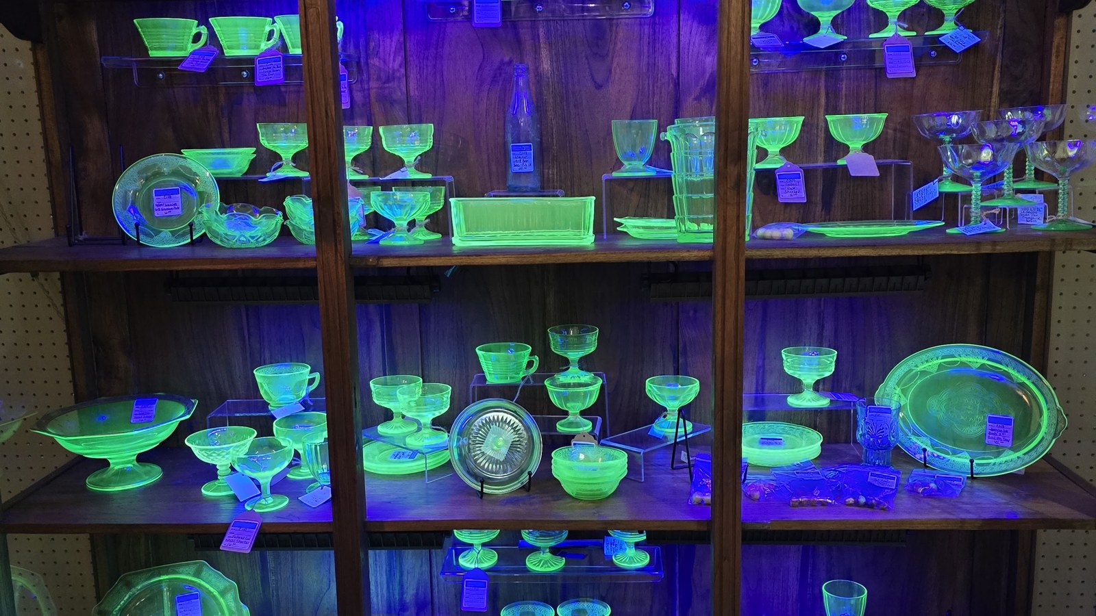 Cabinet of glowing green uranium glass and vintage stemware at Heritage Square Antique Mall