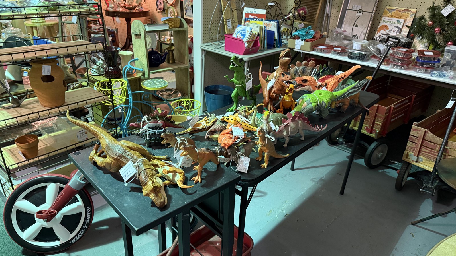 Table filled with dinosaur toys and curios inside Heritage Square Antique Mall