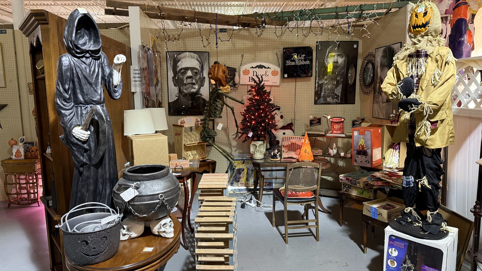Seasonal booth with Halloween decor, signs, and collectible displays at Heritage Square Antique Mall