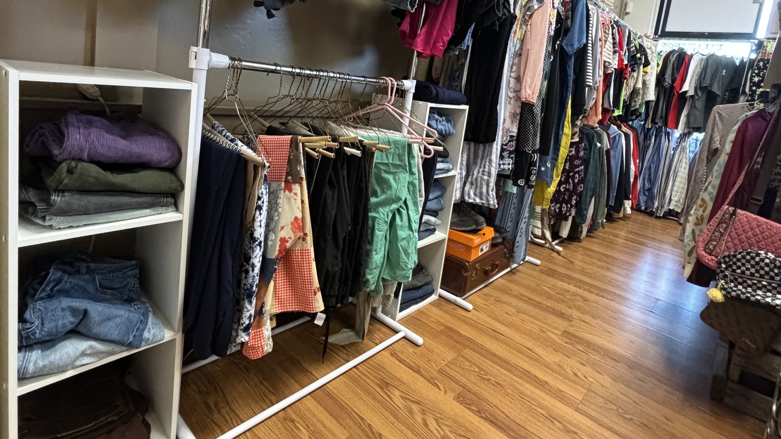 Long row of hanging clothes and folded pieces inside Khlovan's Thrift