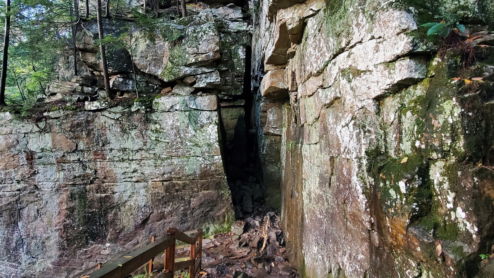 Rockhouse Falls tucked beside a rugged cavern wall and stone overlook railing.