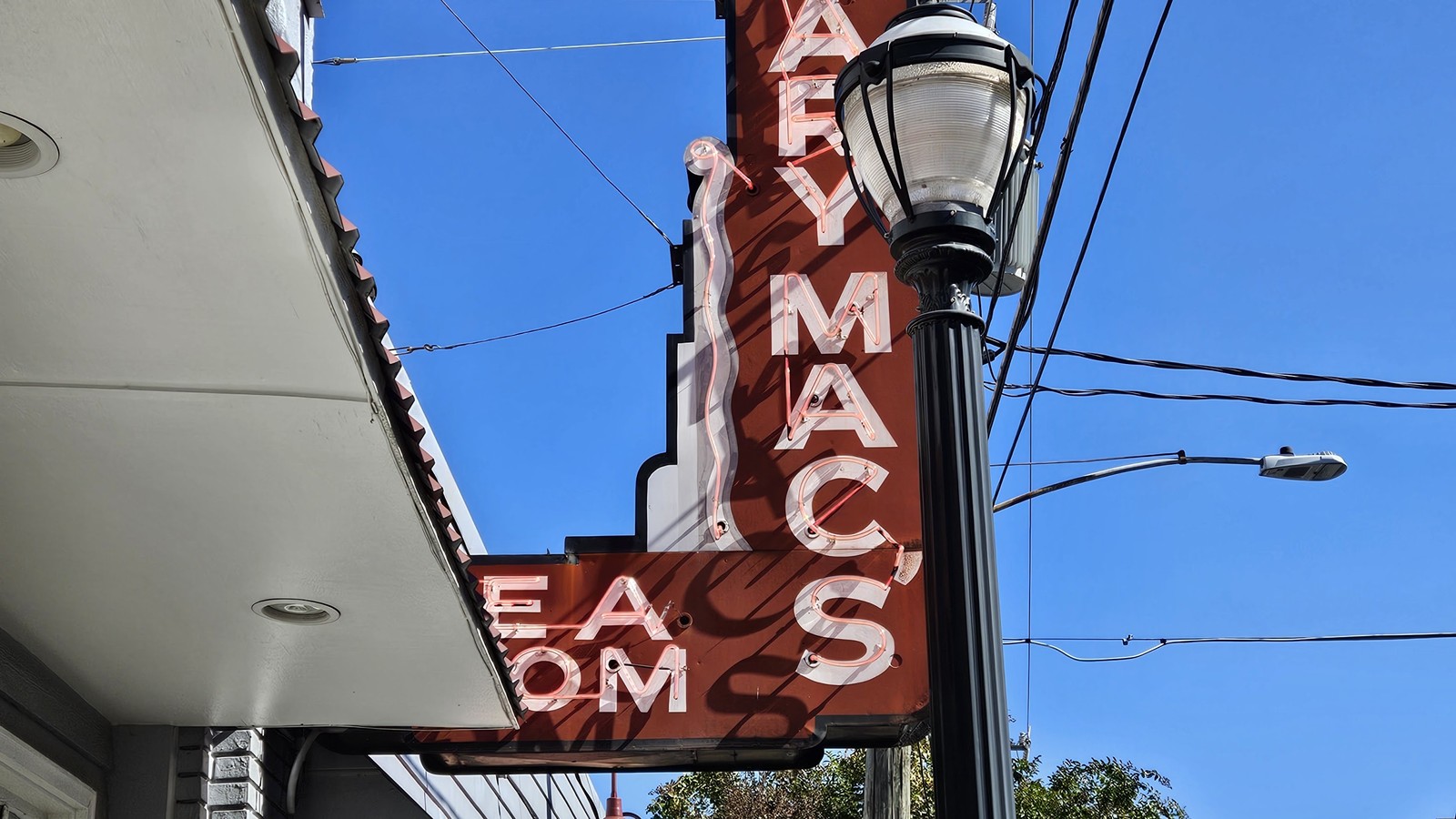 Mary Mac's neon sign rising over the sidewalk and blue Atlanta sky