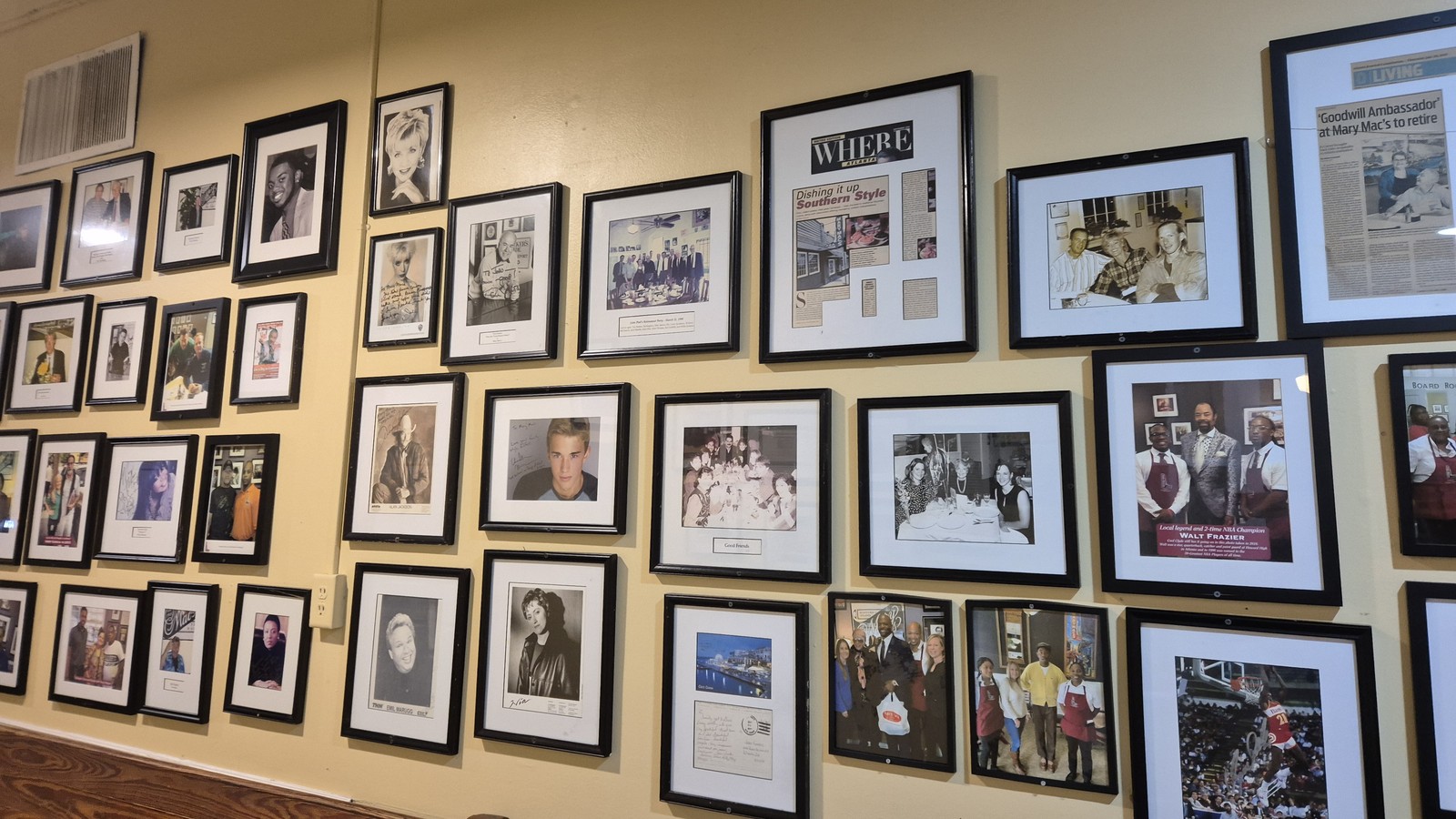 Framed celebrity and guest photos covering one wall inside Mary Mac's Tea Room