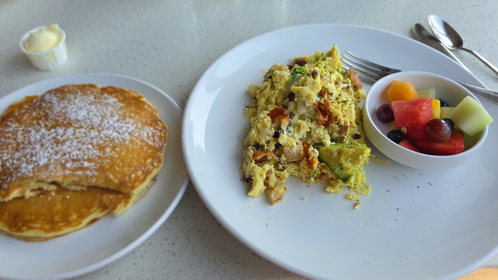 Scramble plate with a powdered-sugar pancake and fruit at Butters Pancakes & Cafe